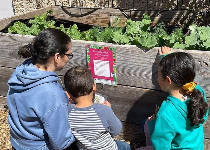 woman and two children looking at a raised garden bed